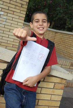 young boy at school giving a thumbs up
