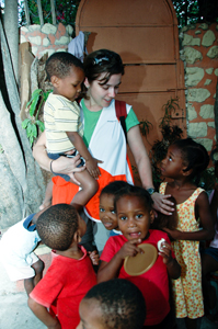 A World Vision relief worker helps Haitian children at distribution center World Vision, relief workers in Haiti