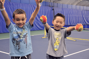 The QuickStart tennis program (www.10andundertennis.com) is supported by advocates like First Lady Michelle Obama in her Let’s Move anti-obesity campaign. Obama champions the program’s efforts to make exercise fun for kids, saying “Now it’s easier than ever to play an hour a day, every day.” Two little boys on tennis court
