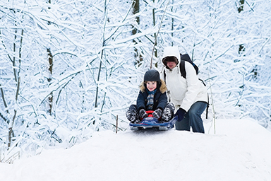 sledding safety tips child wearing helmut while sledding