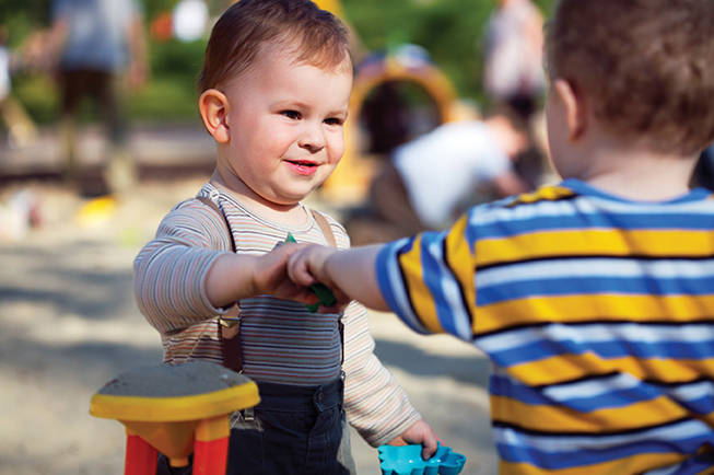 toddlers sharing a toy