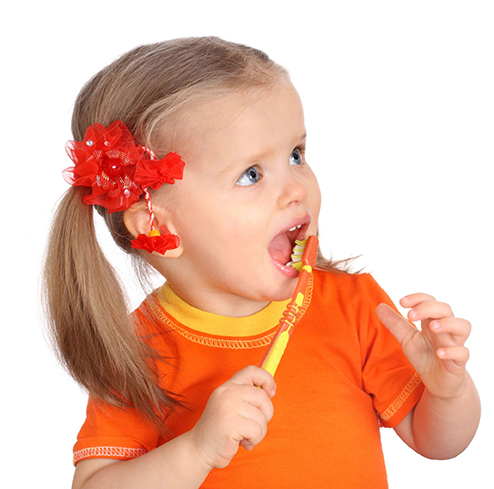 When should my child begin using fluoride toothpaste? toddler brushing teeth